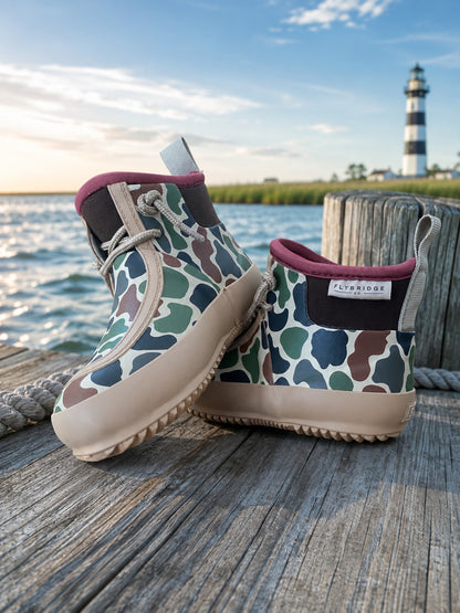 Pair of Little Skipper duck camo boots on a dock